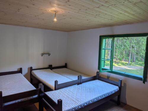 two beds in a room with a window at Chata POUSTEVNA ( Střelecká ) in Vrbno pod Pradědem