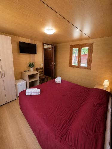 a bedroom with a large bed with a red blanket at Chalet - Snow Village Roccaraso in Roccaraso