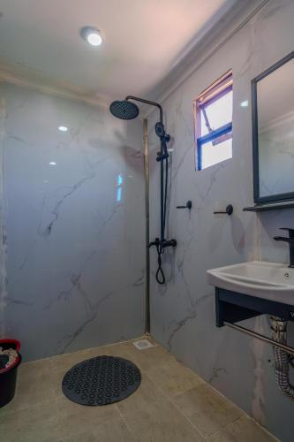 a bathroom with a shower and a sink at Maya Stays in Busia