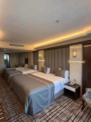 a hotel room with two beds and a couch at Green Prusa Hotel in Bursa
