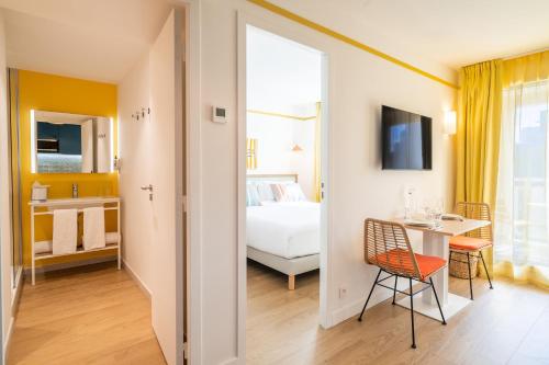 a room with a bed and a table and a bedroom at Appartements Soléo Prado in Marseille