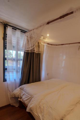 a bedroom with a bed and a window at Maya Stays in Busia