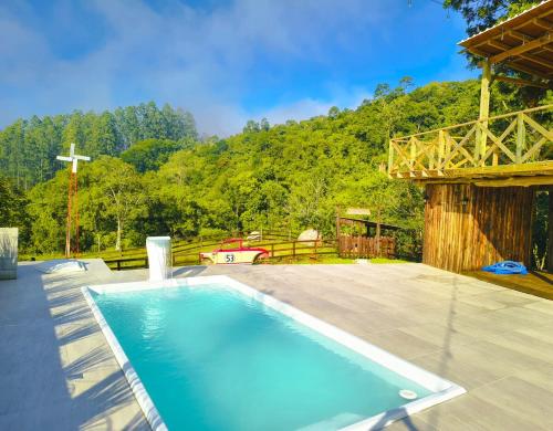 a large swimming pool in a yard with a cross at Villa Pitanga Pousada in São Martinho