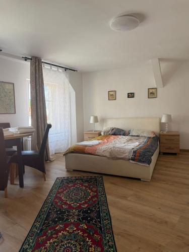 a bedroom with a bed and a table and a desk at Przy Żelaznym Moście in Kłodzko