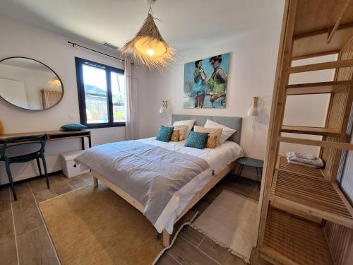 a bedroom with a bed and a desk and a mirror at Villa Céline - Prestige, Piscine & Jacuzzi in Vielle-Saint-Girons