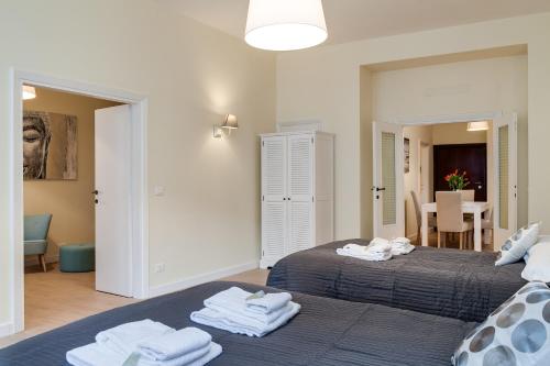 Dos camas en una habitación con toallas. en Romefinestay Apartments Sistina, en Roma