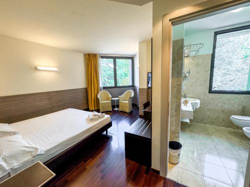 a hotel room with a bed and a bathroom at Continental Urban Art Hotel in Zola Predosa