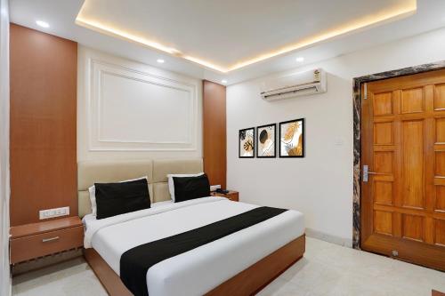 a bedroom with a large bed and a wooden door at Hotel O by OYO S R Galaxy in Kānpur