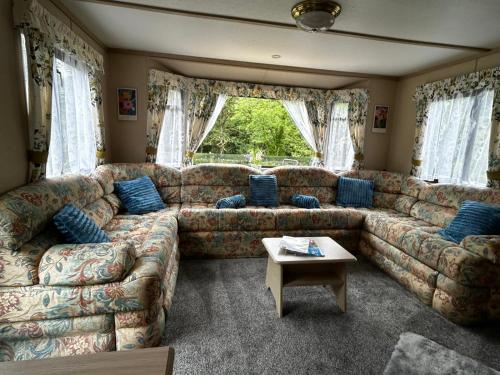 a large living room with couches and a table at 48 River View in Dunoon