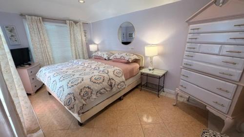 a bedroom with a bed with a dresser and a dresser at The Independent Inn in Key West