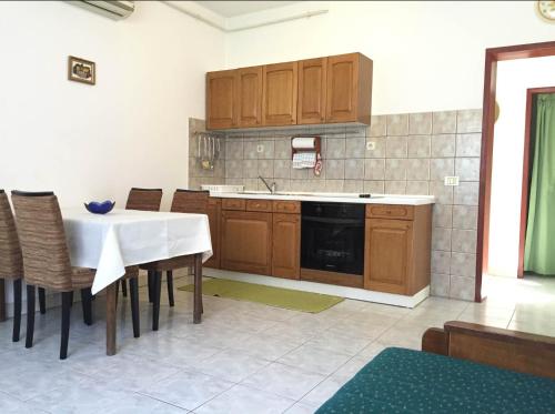 a kitchen with wooden cabinets and a table and chairs at House Dina in Pula