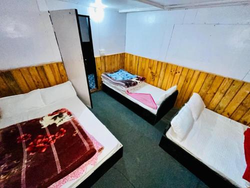 a room with two beds and a chair in it at Hotel sangam kalinchok kuri in Dolakhā