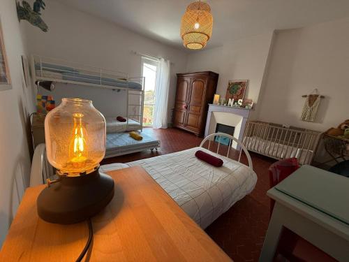 a room with a bed and a lamp on a table at Le Balcon des Pourcelles in Les Mées