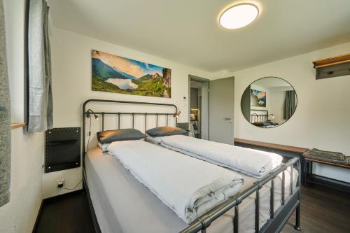 a bed in a room with a mirror at Clarke's Lakeside Chalet 1 in Leissigen