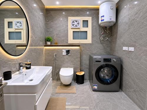 a bathroom with a washing machine and a sink at Spacious 3BR Apartment in Prime Sheikh Zayed in Sheikh Zayed