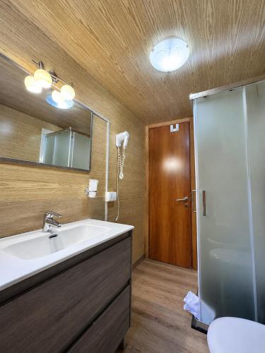 a bathroom with a sink and a mirror and a shower at Chalet - Snow Village Roccaraso in Roccaraso