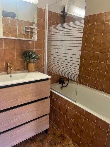 a bathroom with a tub and a sink at Riviera Lodge II in Allos