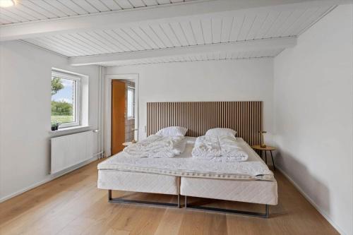 a white bedroom with a large bed in it at 80324-Ulfborg-Munkhulevej-6 in Staby