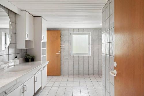 a bathroom with a sink and a door with a window at 80324-Ulfborg-Munkhulevej-6 in Staby
