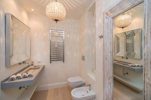 a white bathroom with a sink and a toilet at Brera Luxury Suite in Milan