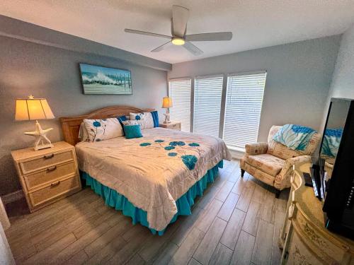 a bedroom with a bed and a fan and a chair at 2BR/1BA Sienna Park Apartment in Sarasota