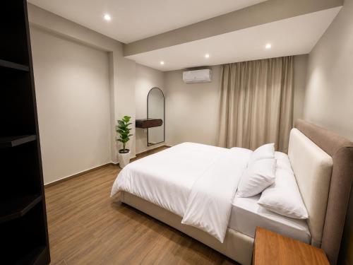 a bedroom with a white bed and a couch at Spacious 3BR Apartment in Prime Sheikh Zayed in Sheikh Zayed