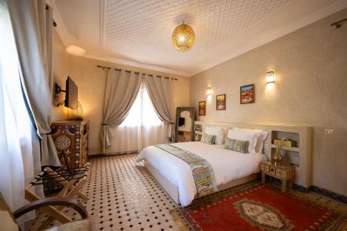 a bedroom with a white bed and a window at Villa du Cedre in Marrakesh