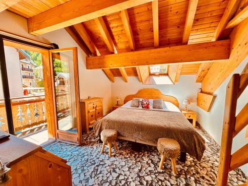 a bedroom with a bed with two stools in it at Hôtel-Chalet les Mélèzes in Valloire