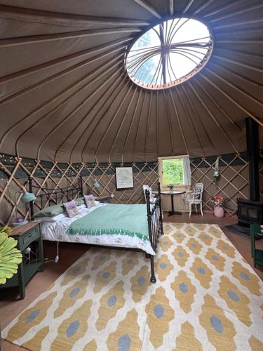 a bedroom in a yurt with a bed and a window at Thistlebank Yurt in Llangollen
