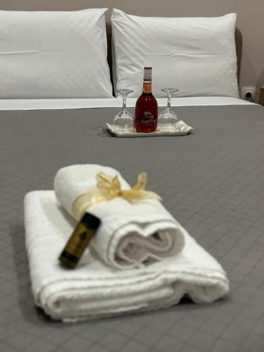 a bed with towels and a bottle of wine and glasses at Stv Royal Appartments in Areopoli