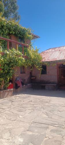 a brick building with plants on the side of it at TAQUILE LODGE Perú in Huillanopampa