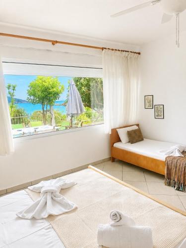 a living room with a bed and a large window at ENDLESS BLUE WAVE in Paleo Tsifliki