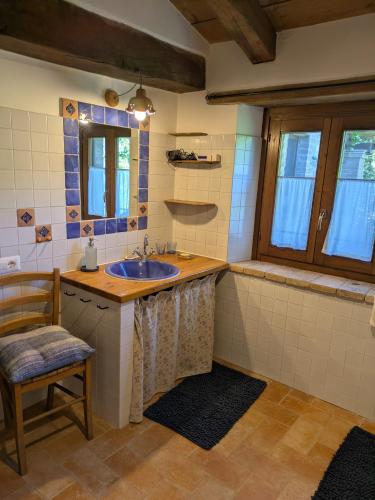 a bathroom with a sink and a chair at Agriturismo Frallarenza in Ficulle