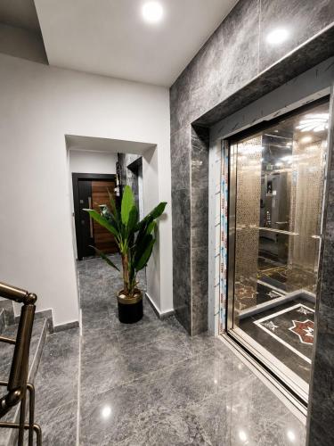 a room with a glass door and a potted plant at Airport Deluxe Suites Otel in Trabzon