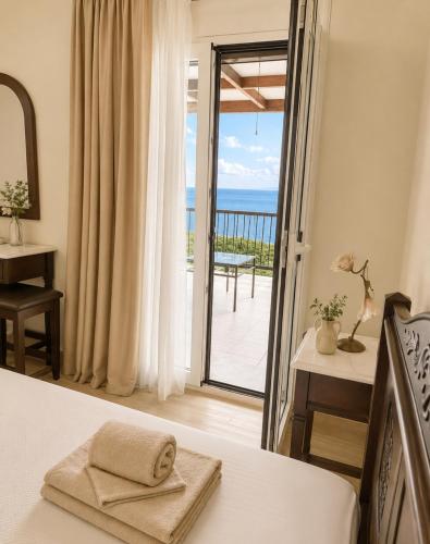 a bedroom with a bed and a view of the ocean at Villa Vera in Agios Nikitas