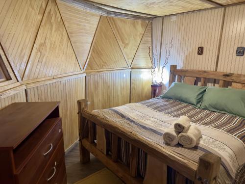 a bedroom with a wooden bed with towels on it at Oceana Suites Coyhaique in Puerto Dunn