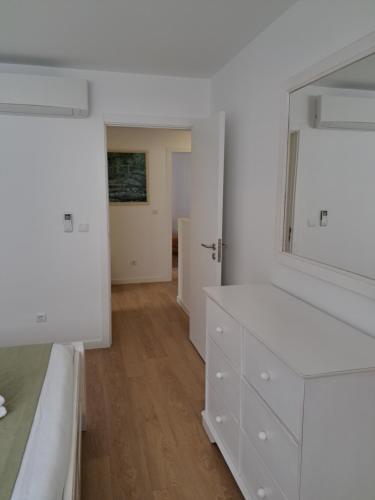 a white bedroom with a bed and a dresser at Furnas Springs in Furnas