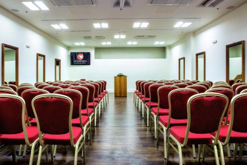 an empty room with red chairs and a podium at Nymfasia Resort in Vytina