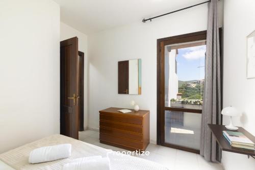 a bedroom with a bed and a window and a dresser at Il terrazzo sulla duna 6 by Propertize in Torre Dei Corsari
