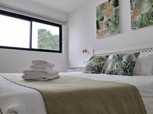a white bedroom with a bed with towels on it at Furnas Springs in Furnas