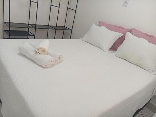 ein Bett mit zwei Handtüchern und Kissen darauf in der Unterkunft Executivo central 101 in Ipatinga