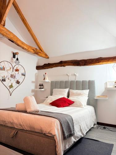 a bedroom with a large bed with white and red pillows at CASA DO CONDE MONTIER in Paredes de Coura