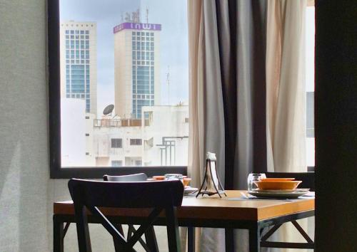 a dining room table with a view of a city at Suite Loc Suite & Spa in Casablanca