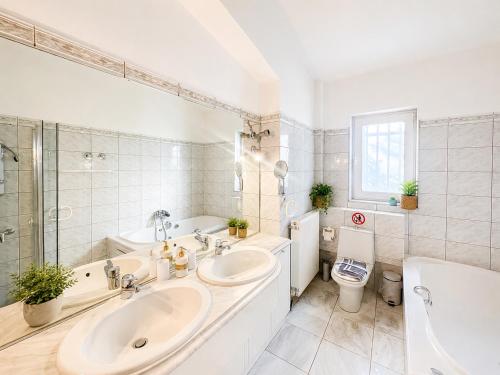 a bathroom with two sinks and a tub and a toilet at ENDLESS BLUE WAVE in Paleo Tsifliki