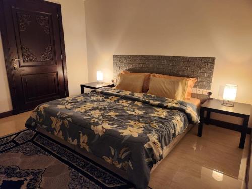 a bedroom with a bed with two tables and two lamps at Shahan Residence in Muscat