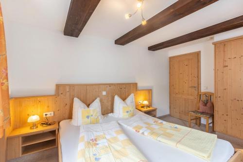 a bedroom with a large white bed with wooden headboard at Ferienhof Pohl-Optimal für Familien in Lennestadt