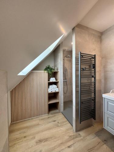a bathroom with a walk in shower next to a staircase at Le Nid - Pause en Berry in Vignoux-sur-Barangeon