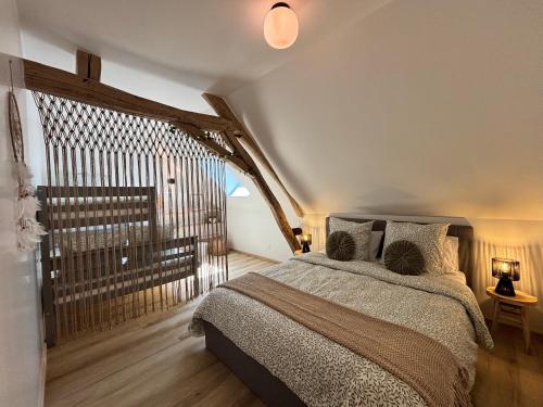 a bedroom with a bed and a large window at Le Nid - Pause en Berry in Vignoux-sur-Barangeon