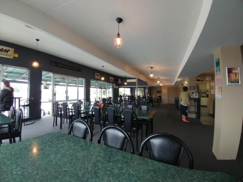 a dining room with tables and chairs in a restaurant at Pineacres Motel and Park in Kaiapoi