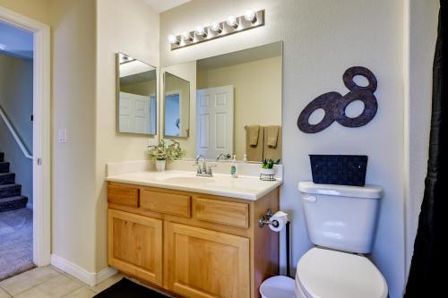 a bathroom with a toilet and a sink and a mirror at Golf & Gamble! Mesquite Condo w/ Pool Access in Mesquite